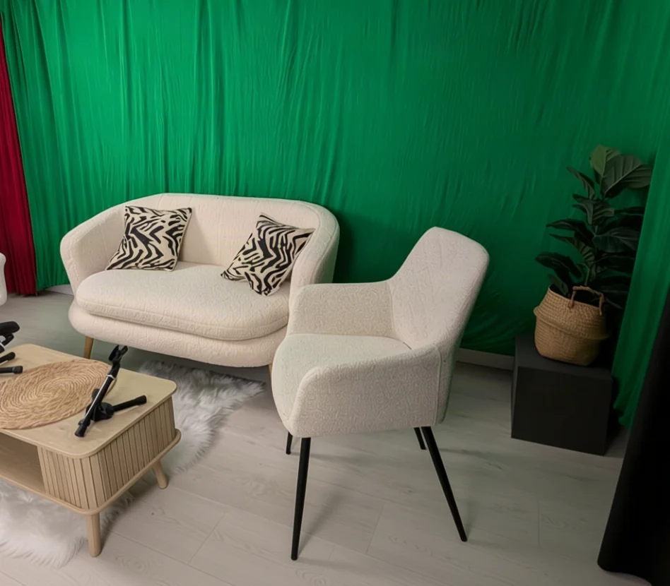 Sofá y sillones blancos delante del croma verde